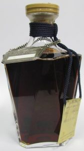 75cl with an old type hanging card and a metal plaquette